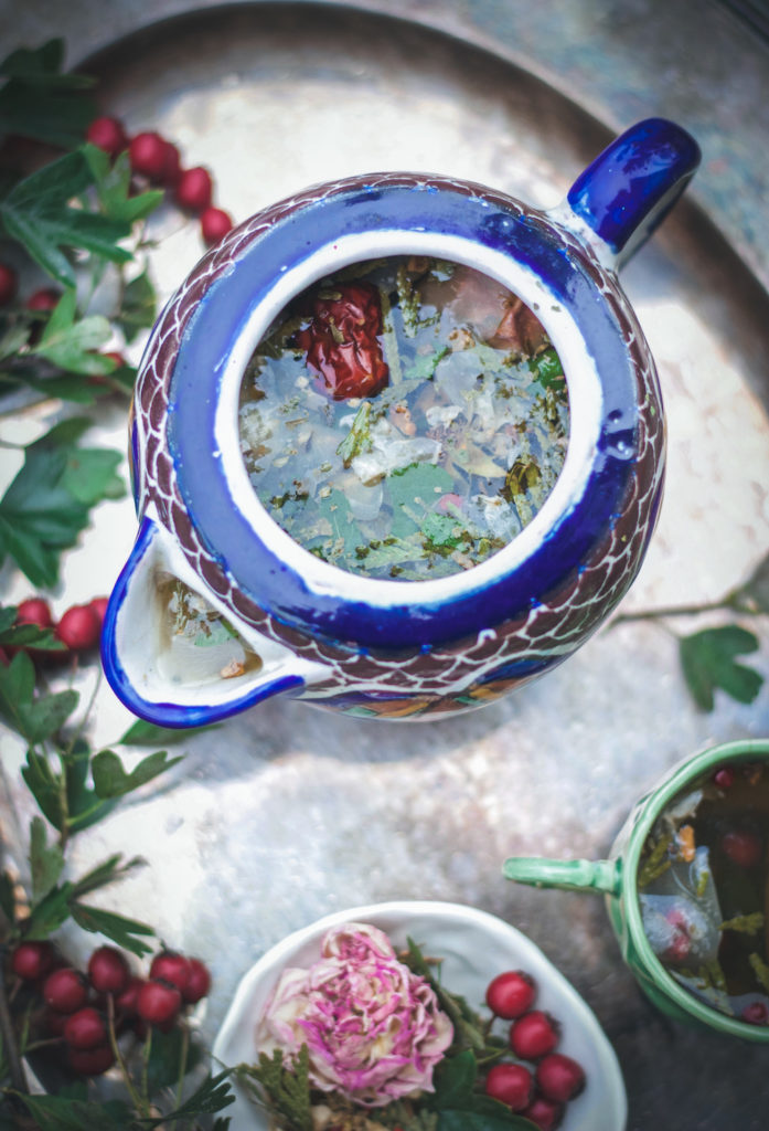 close up of an herbal tea blend in a blue and brown tea pot