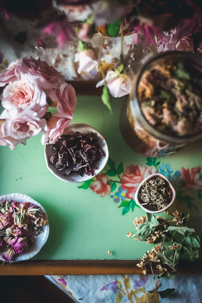 herbal tea ingredients on green tray with pink roses