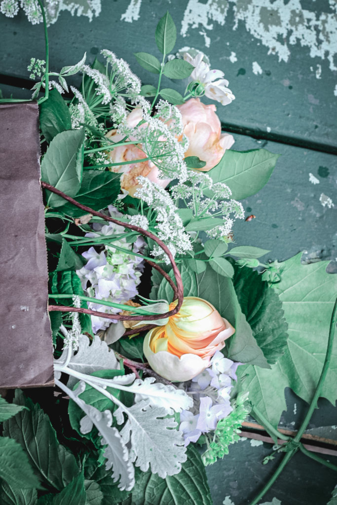 bag of flowers on green bench